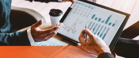 Hands reviewing charts on a tablet, representing Evaluating Investments in the Finance Certificate program.