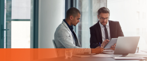 wo professionals reviewing data on laptop and tablet, for Understanding Financing Costs in the Finance Certificate.